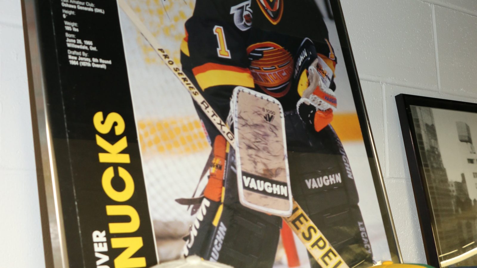 vintage caps on shelf with vintage canucks poster in background